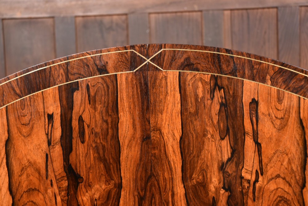 A circular Victorian rosewood tilt-top table featuring highly figured timber grain, a deep apron, a carved central pedestal column, and a quadform base on carved claw feet. View IV