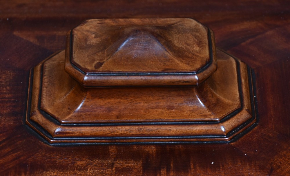 A Victorian mahogany sarcophagus-shaped cellarette featuring carved corner pilasters, a stepped hinged lid, and carved scroll feet. View V