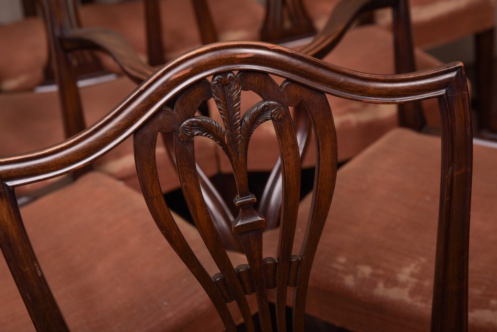 A set of eight dark mahogany Hepplewhite-style dining chairs featuring carved shield backs and rust-coloured upholstered seats. View II