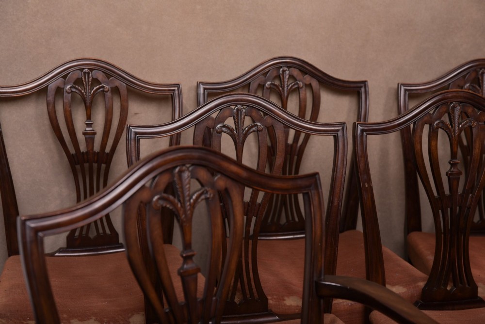 A set of eight dark mahogany Hepplewhite-style dining chairs featuring carved shield backs and rust-coloured upholstered seats. View III