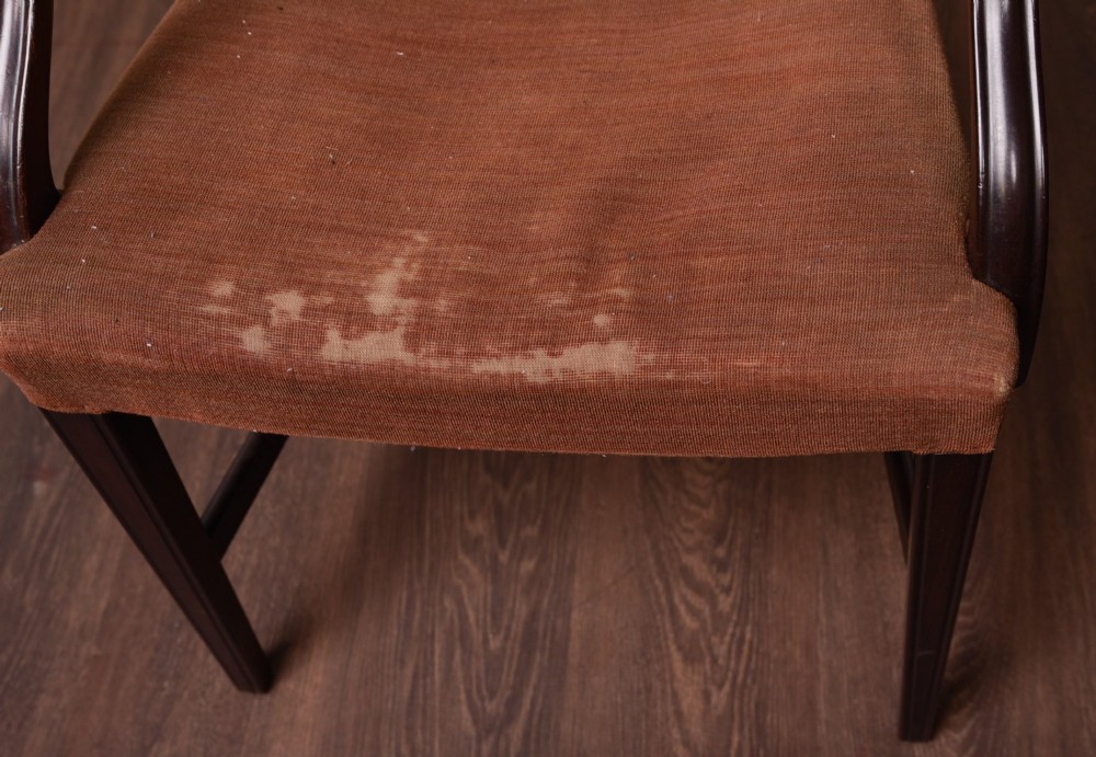 A set of eight dark mahogany Hepplewhite-style dining chairs featuring carved shield backs and rust-coloured upholstered seats. View VII