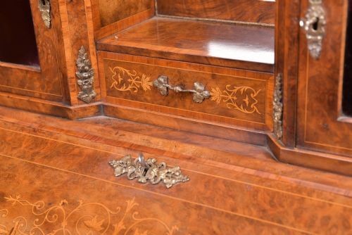 An antique French walnut ladys writing desk featuring floral marquetry, cabriole legs, brass mounts, and a raised upper section with glass cabinets and a central mirror. View III