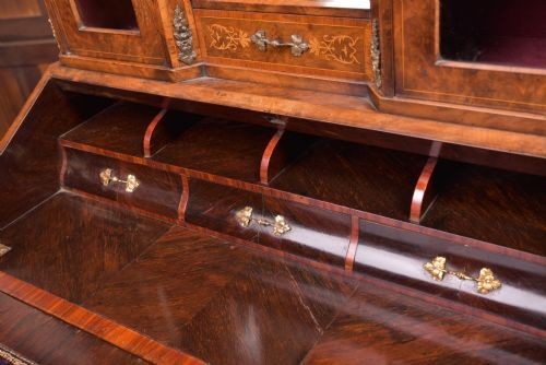 An antique French walnut ladys writing desk featuring floral marquetry, cabriole legs, brass mounts, and a raised upper section with glass cabinets and a central mirror. View IV