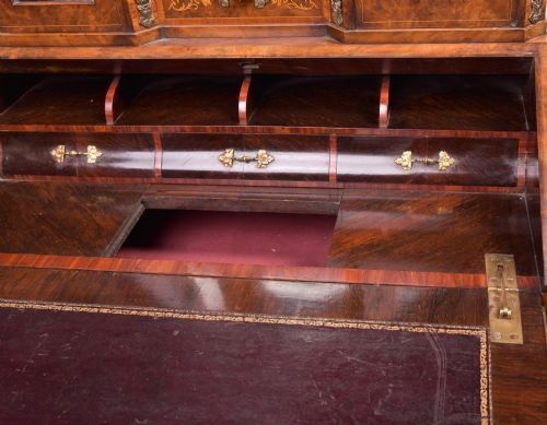 An antique French walnut ladys writing desk featuring floral marquetry, cabriole legs, brass mounts, and a raised upper section with glass cabinets and a central mirror. View IX