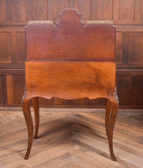 An antique French walnut ladys writing desk featuring floral marquetry, cabriole legs, brass mounts, and a raised upper section with glass cabinets and a central mirror. View XII