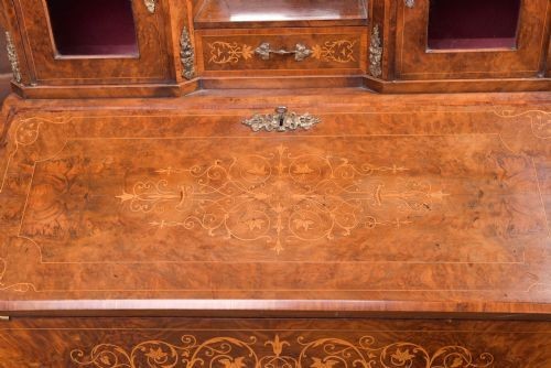 An antique French walnut ladys writing desk featuring floral marquetry, cabriole legs, brass mounts, and a raised upper section with glass cabinets and a central mirror. View XIII