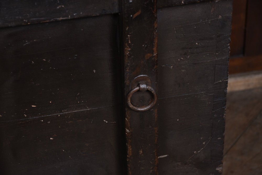 A dark brown Japanese wooden storage chest set on small wheels with vertical timber battens and hand-forged iron fittings. View III