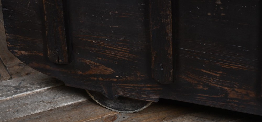 A dark brown Japanese wooden storage chest set on small wheels with vertical timber battens and hand-forged iron fittings. View V