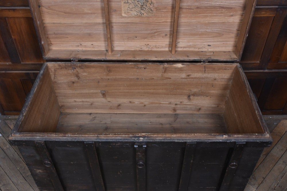 A dark brown Japanese wooden storage chest set on small wheels with vertical timber battens and hand-forged iron fittings. View VIII