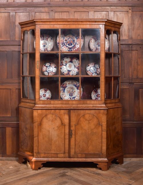 A nineteenth-century Dutch walnut display cabinet featuring a glazed upper section with individual glass panes and a lower cupboard with arched panelled doors resting on bracket feet. View II