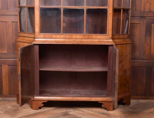 A nineteenth-century Dutch walnut display cabinet featuring a glazed upper section with individual glass panes and a lower cupboard with arched panelled doors resting on bracket feet. View III