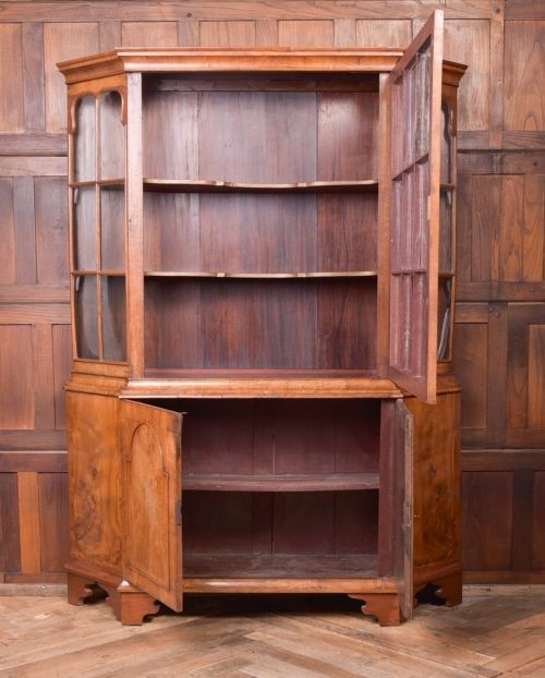A nineteenth-century Dutch walnut display cabinet featuring a glazed upper section with individual glass panes and a lower cupboard with arched panelled doors resting on bracket feet. View IV