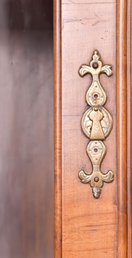 A nineteenth-century Dutch walnut display cabinet featuring a glazed upper section with individual glass panes and a lower cupboard with arched panelled doors resting on bracket feet. View VII