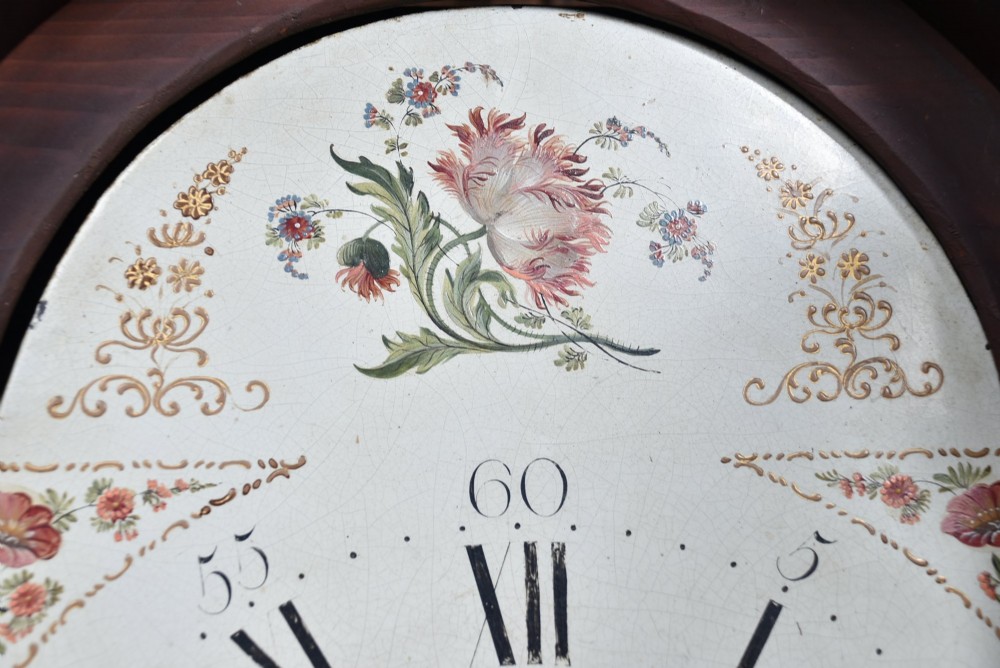 Victorian flame mahogany longcase clock featuring a swan-neck pediment, arched painted dial with floral spandrels, and a tall veneered trunk door. View III