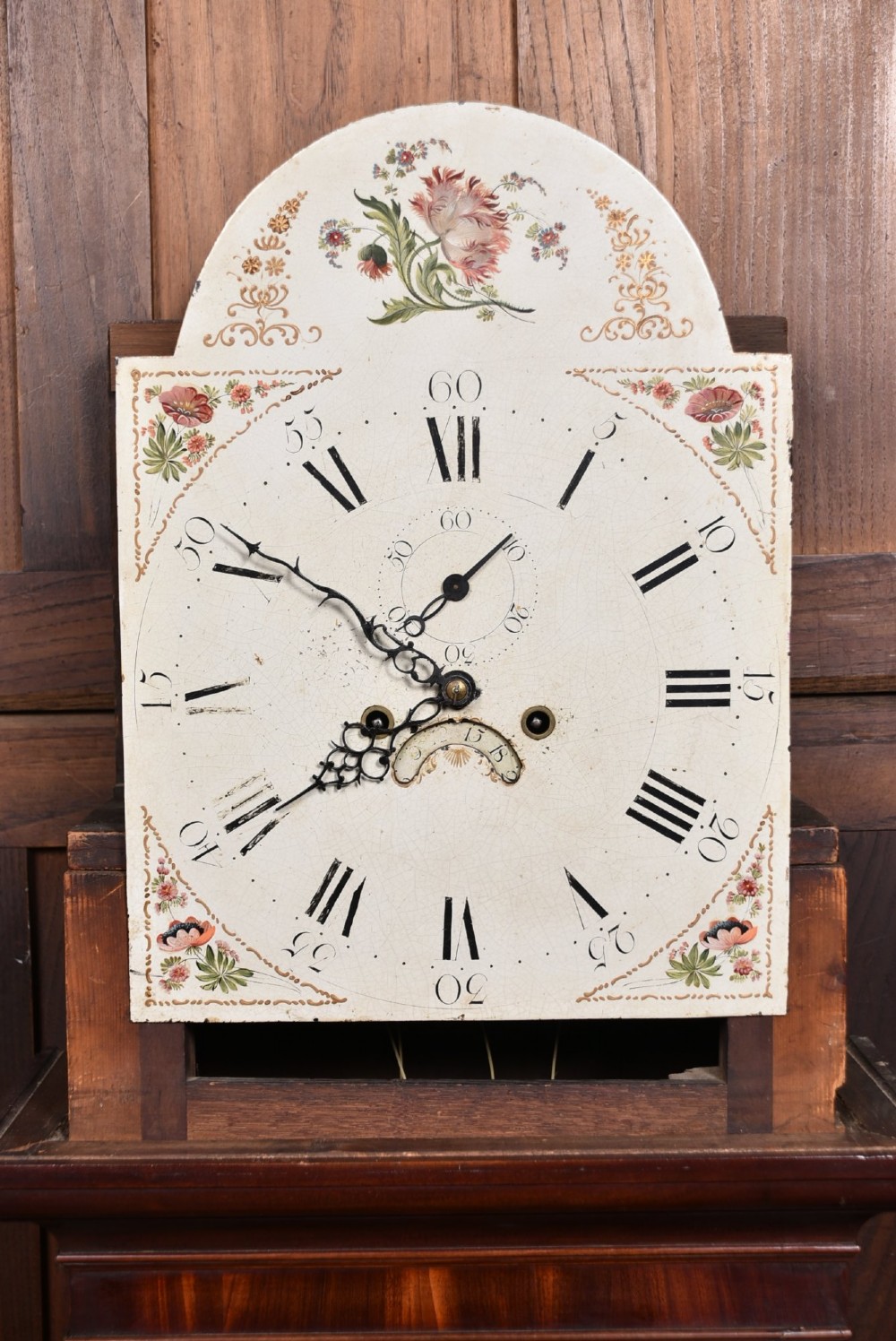 Victorian flame mahogany longcase clock featuring a swan-neck pediment, arched painted dial with floral spandrels, and a tall veneered trunk door. View VII