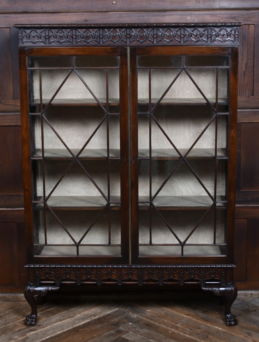 A dark mahogany Chippendale Revival display cabinet featuring double glazed doors with diamond astragal glazing, blind fretwork frieze, and cabriole legs on ball and claw feet. View II