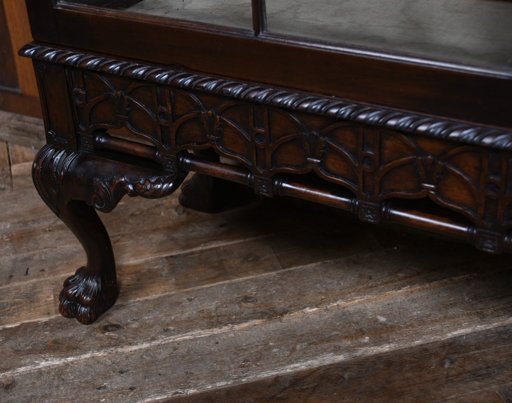 A dark mahogany Chippendale Revival display cabinet featuring double glazed doors with diamond astragal glazing, blind fretwork frieze, and cabriole legs on ball and claw feet. View VI