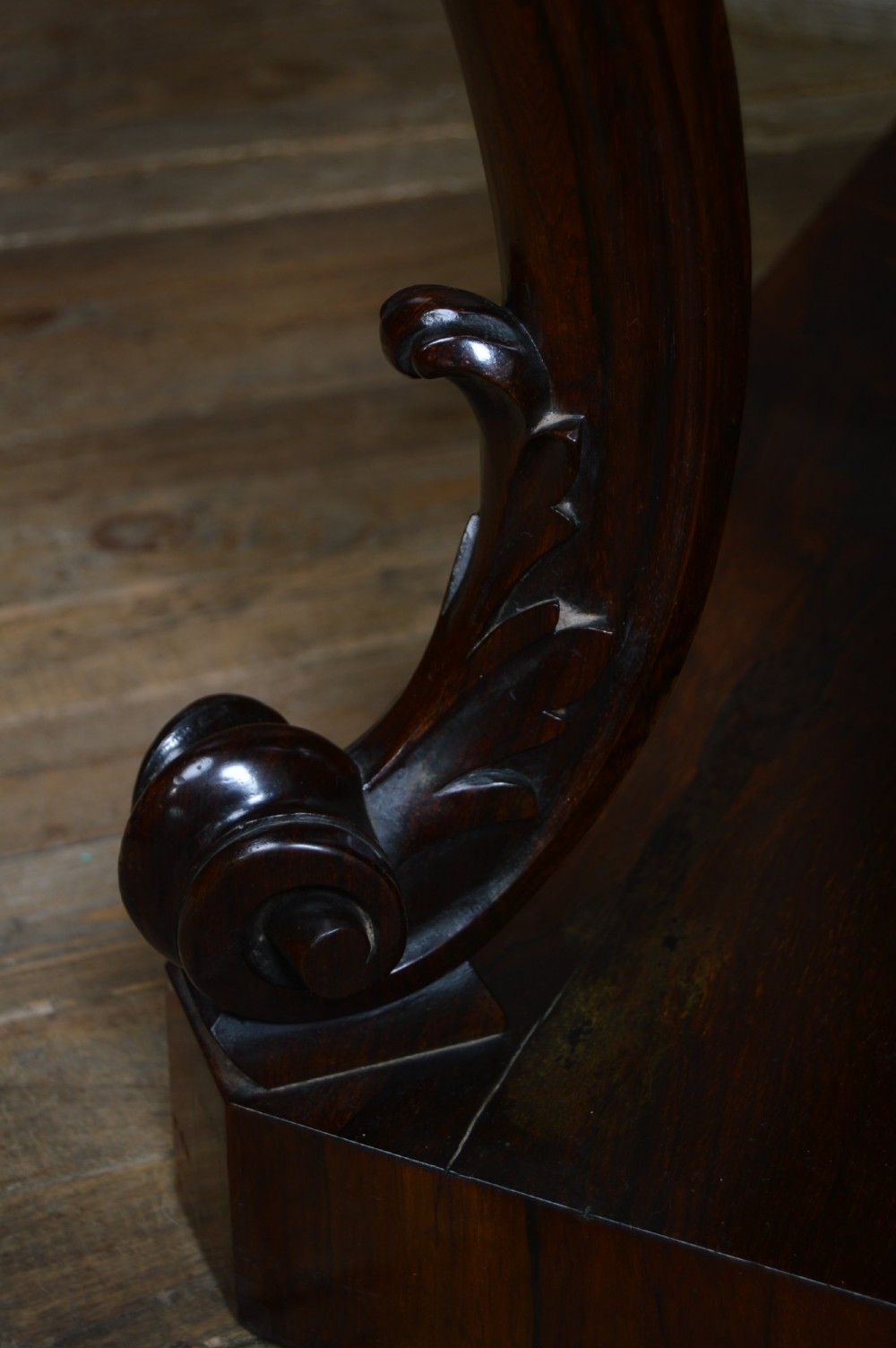 A dark Victorian rosewood console table featuring carved S-scroll supports, an open central shelf, a beaded upper frieze, and a solid plinth base. View XI