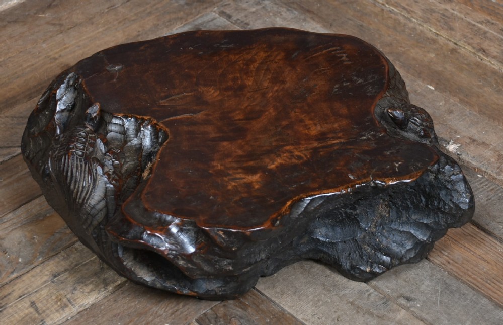 A dark brown carved hardwood display stand featuring a hand-carved turtle motif along the organic natural edge. View II