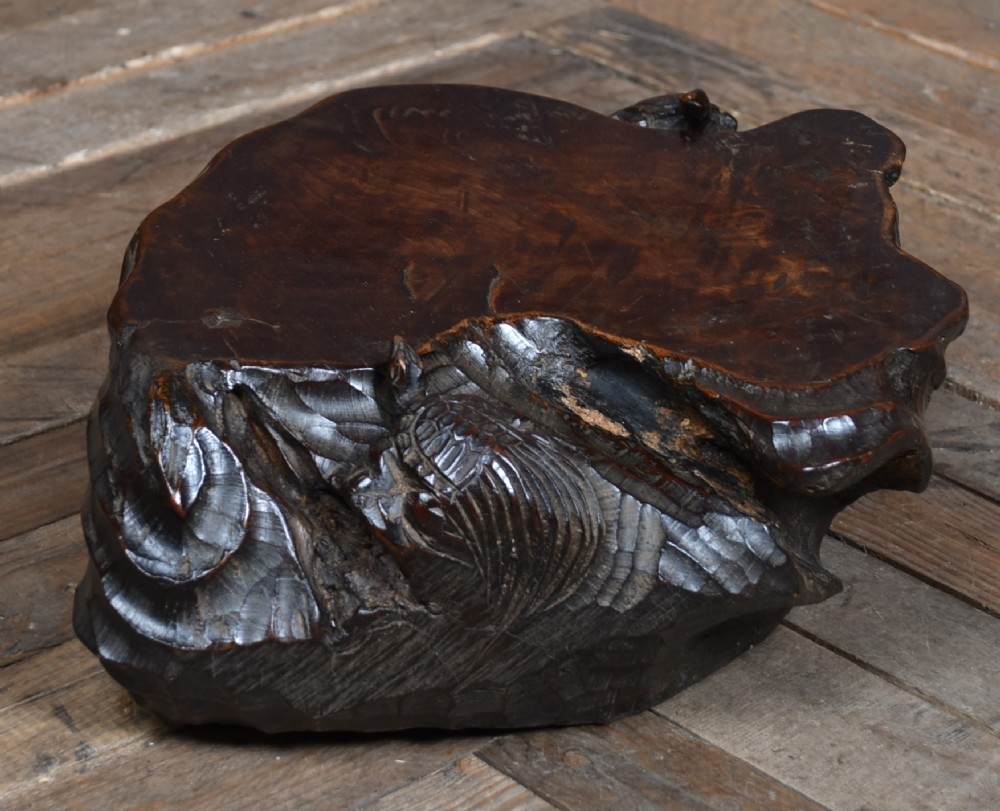 A dark brown carved hardwood display stand featuring a hand-carved turtle motif along the organic natural edge. View III