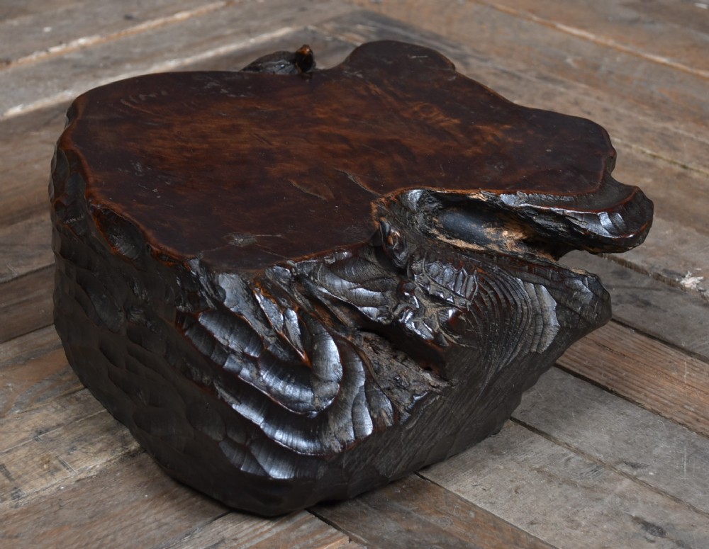 A dark brown carved hardwood display stand featuring a hand-carved turtle motif along the organic natural edge. View VI