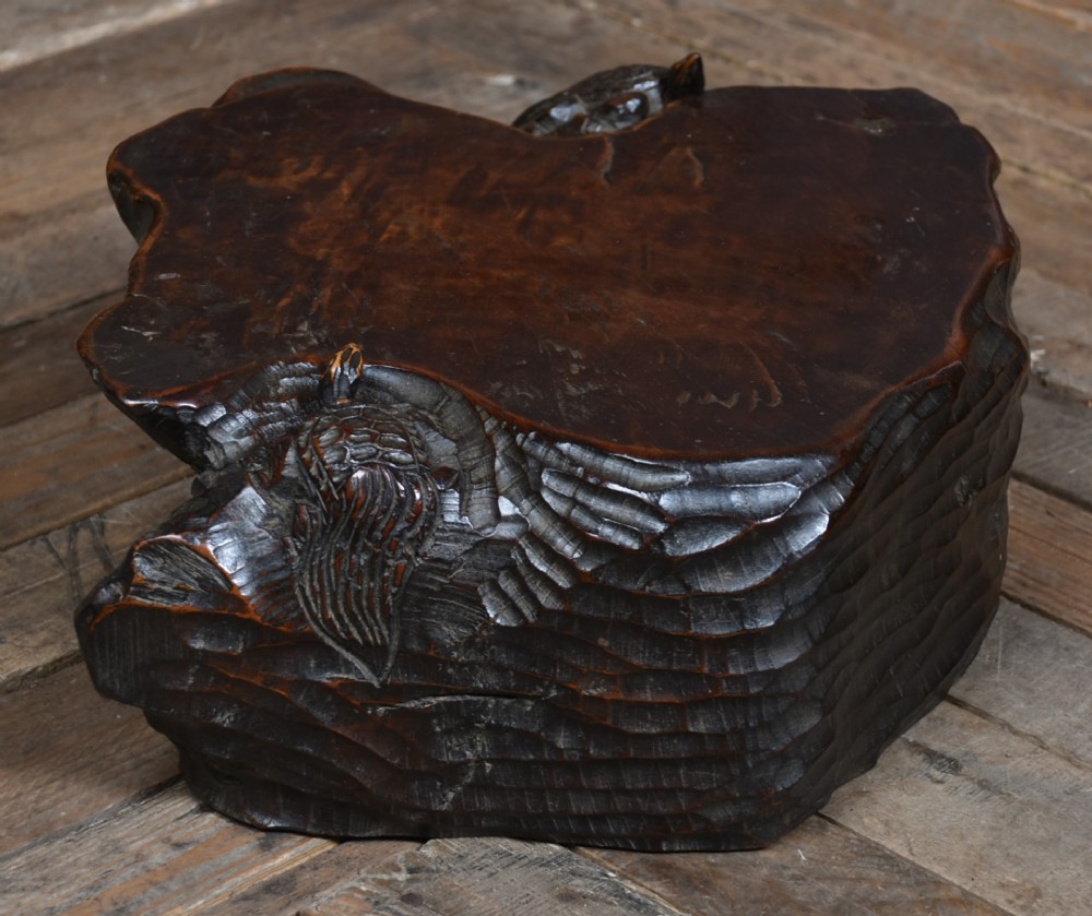 A dark brown carved hardwood display stand featuring a hand-carved turtle motif along the organic natural edge. View IX