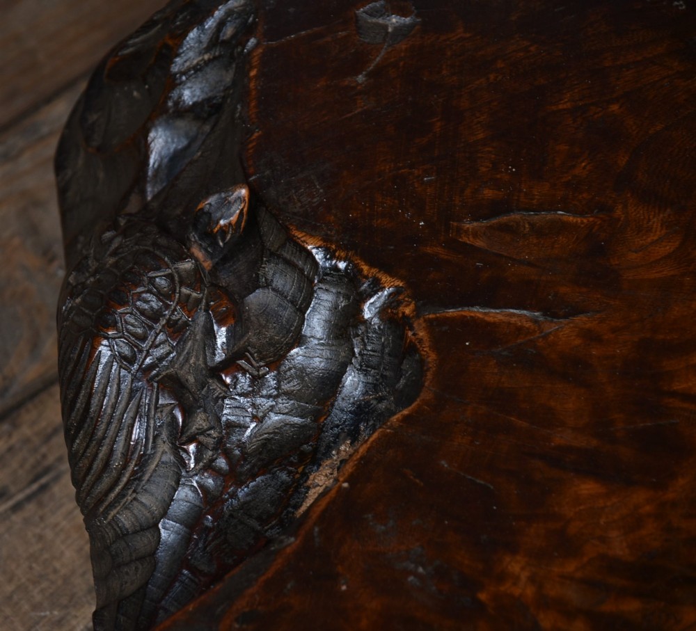 A dark brown carved hardwood display stand featuring a hand-carved turtle motif along the organic natural edge. View XI