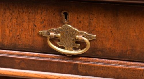 An Edwardian walnut pedestal desk featuring nine drawers with brass swan-neck handles, panelled sides, and bracket feet. View II
