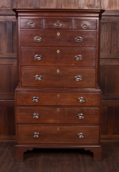 A Georgian mahogany chest-on-chest featuring two stacked drawer units with brass handles and bracket feet.