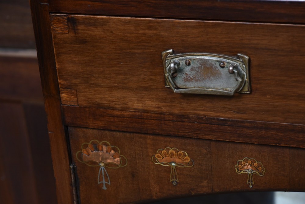 An Art Nouveau dark mahogany display cabinet featuring botanical inlay motifs, glazed upper doors, a central mirrored recess, a single drawer, and curved side brackets. View XIII
