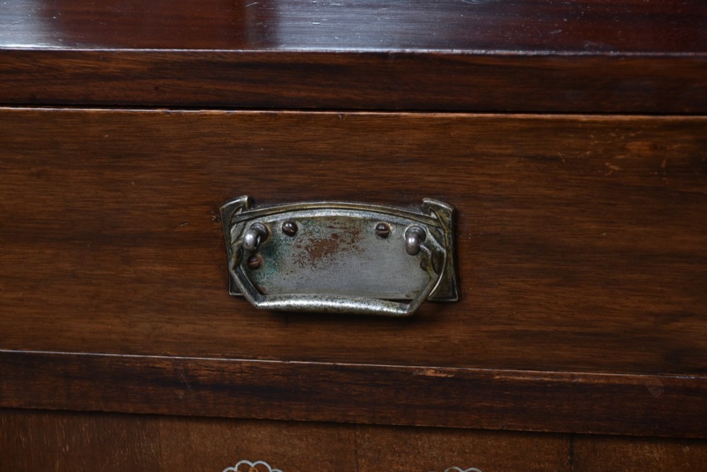 An Art Nouveau dark mahogany display cabinet featuring botanical inlay motifs, glazed upper doors, a central mirrored recess, a single drawer, and curved side brackets. View XIV