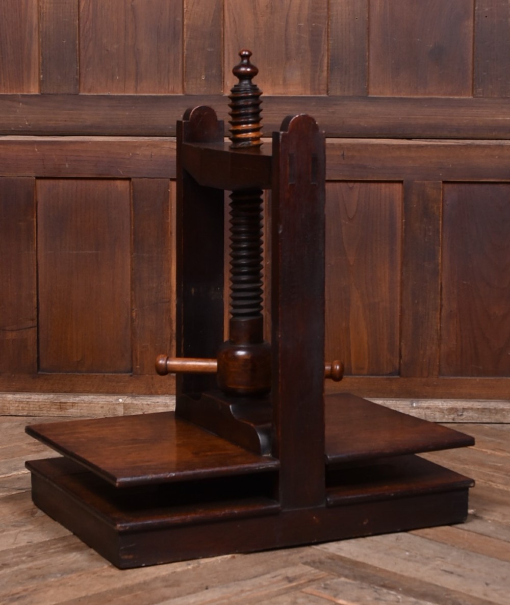 A Victorian dark oak wooden book press featuring a large central hand-turned screw mechanism and solid platen shelves. View II