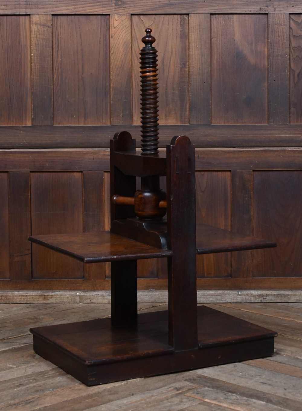 A Victorian dark oak wooden book press featuring a large central hand-turned screw mechanism and solid platen shelves. View III