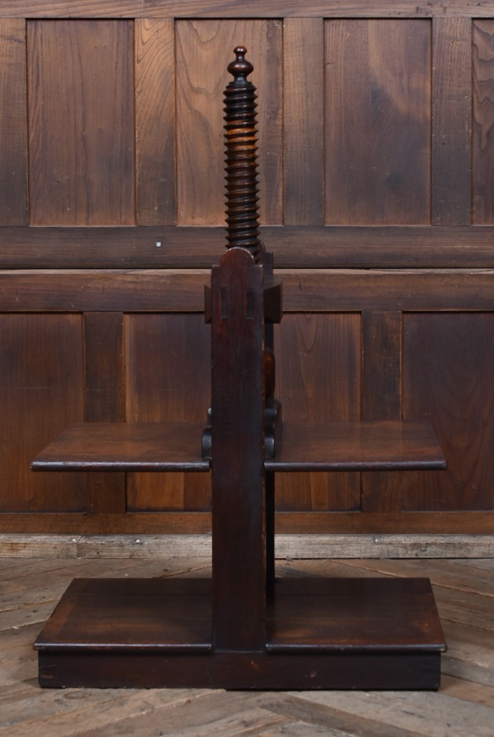 A Victorian dark oak wooden book press featuring a large central hand-turned screw mechanism and solid platen shelves. View IV
