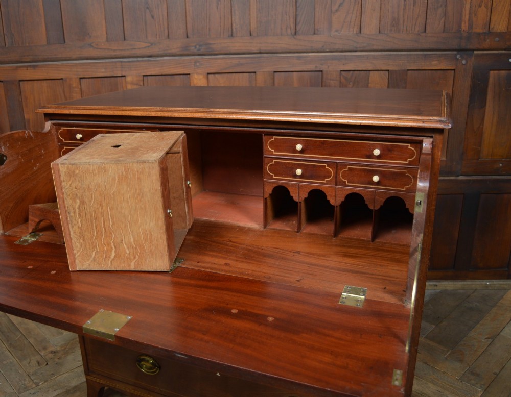 A Regency mahogany secretaire chest featuring oval inlay on the top drawer, brass oval handles, bone escutcheons, and splayed bracket feet. View IV