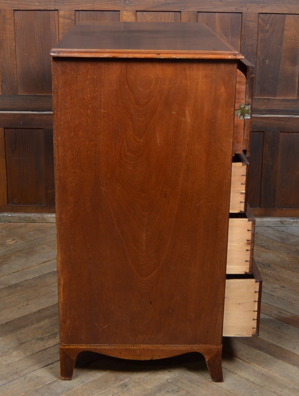 A Regency mahogany secretaire chest featuring oval inlay on the top drawer, brass oval handles, bone escutcheons, and splayed bracket feet. View VII