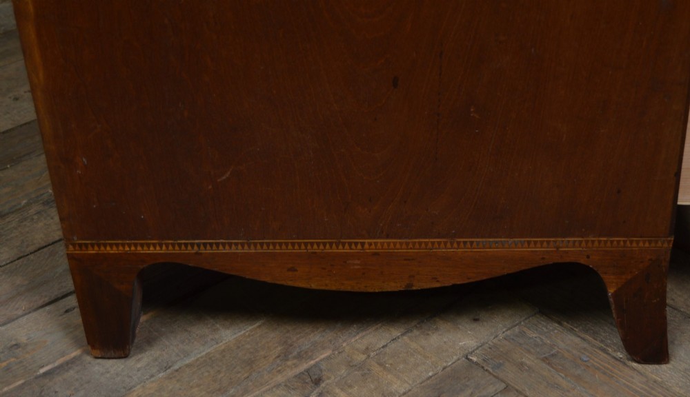 A Regency mahogany secretaire chest featuring oval inlay on the top drawer, brass oval handles, bone escutcheons, and splayed bracket feet. View VIII