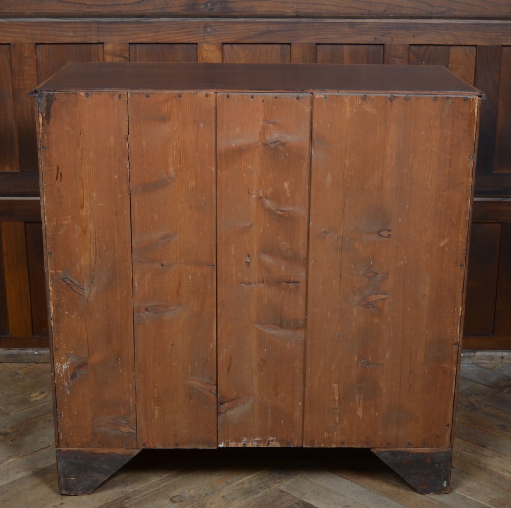 A Regency mahogany secretaire chest featuring oval inlay on the top drawer, brass oval handles, bone escutcheons, and splayed bracket feet. View IX