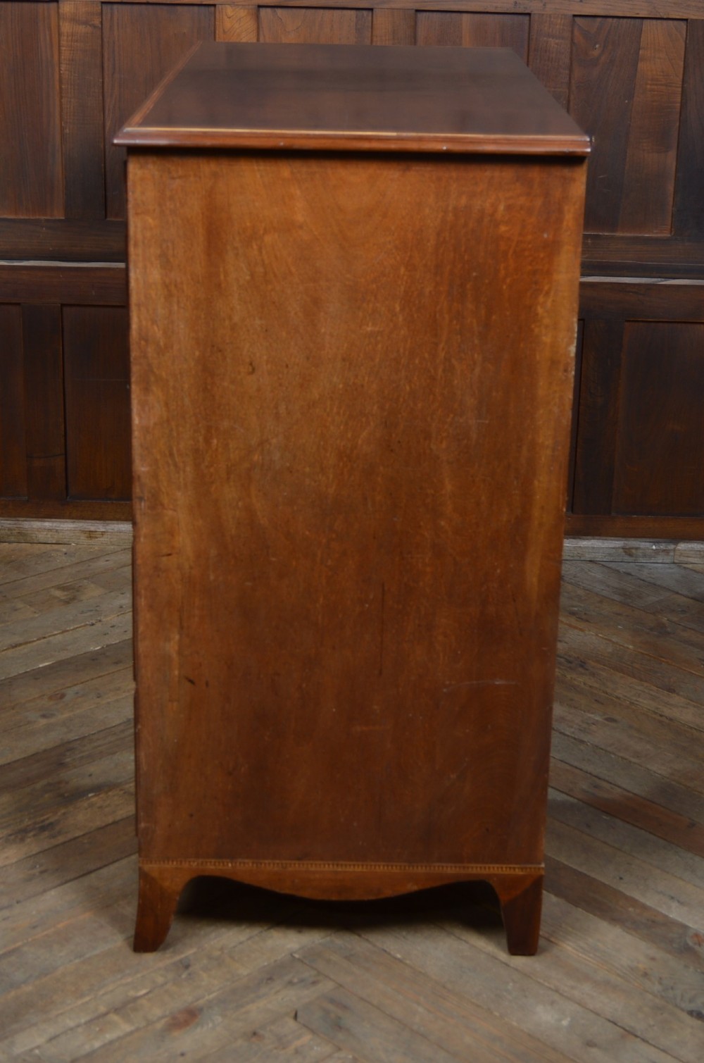 A Regency mahogany secretaire chest featuring oval inlay on the top drawer, brass oval handles, bone escutcheons, and splayed bracket feet. View X