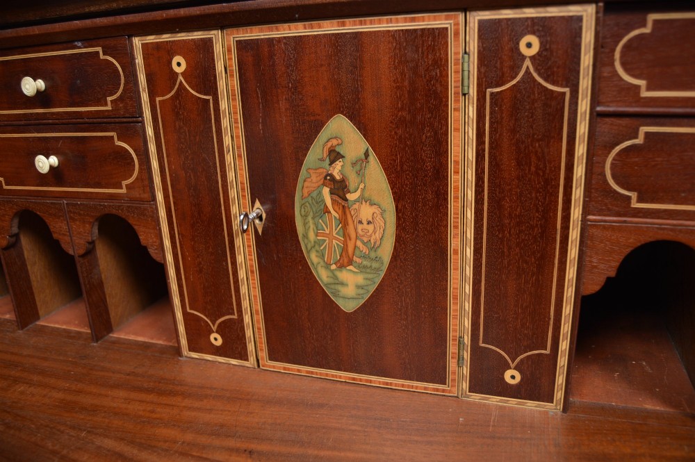 A Regency mahogany secretaire chest featuring oval inlay on the top drawer, brass oval handles, bone escutcheons, and splayed bracket feet. View XIII