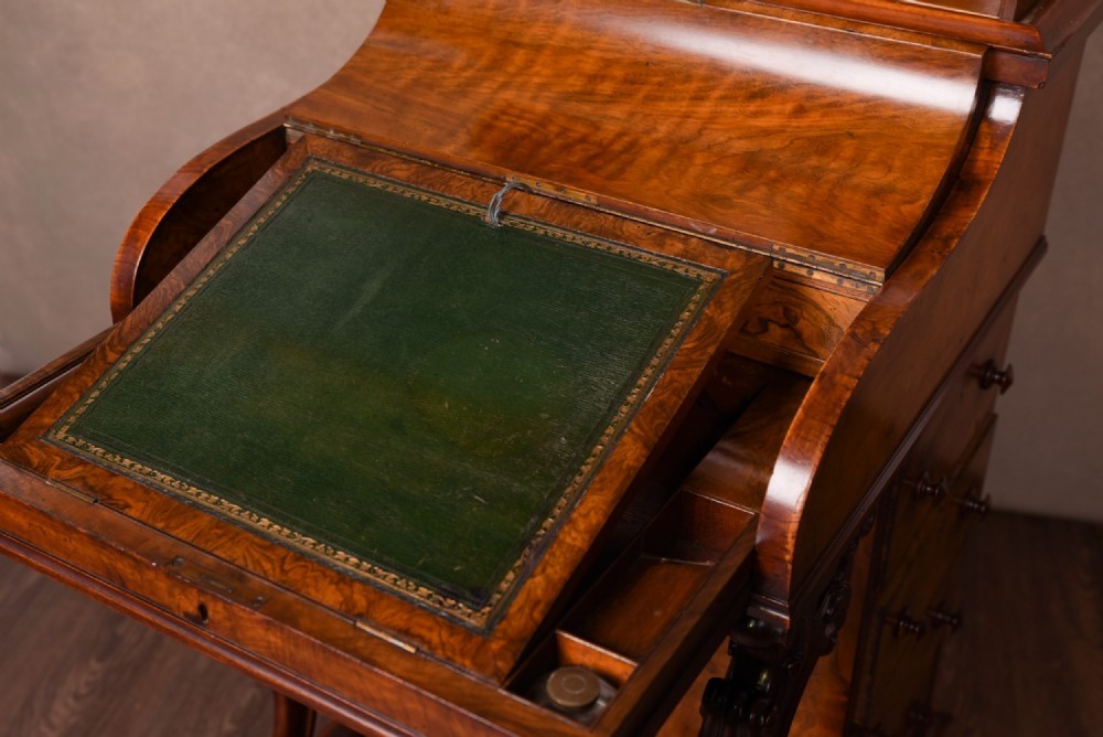 A Victorian burr walnut pop-up Davenport desk featuring carved scroll front supports, side drawers with wooden knobs, and a hinged sloping top. View IV