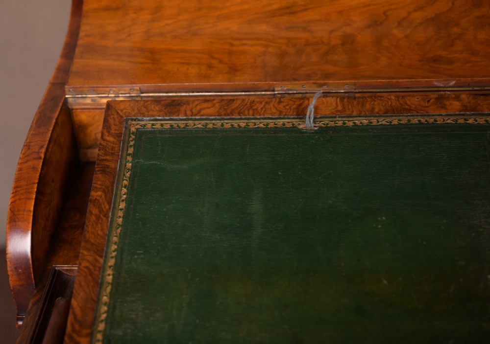 A Victorian burr walnut pop-up Davenport desk featuring carved scroll front supports, side drawers with wooden knobs, and a hinged sloping top. View VI