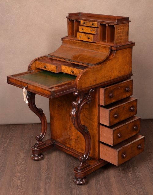 A Victorian burr walnut pop-up Davenport desk featuring carved scroll front supports, side drawers with wooden knobs, and a hinged sloping top. View IX