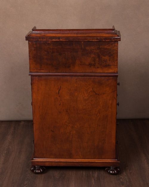 A Victorian burr walnut pop-up Davenport desk featuring carved scroll front supports, side drawers with wooden knobs, and a hinged sloping top. View X