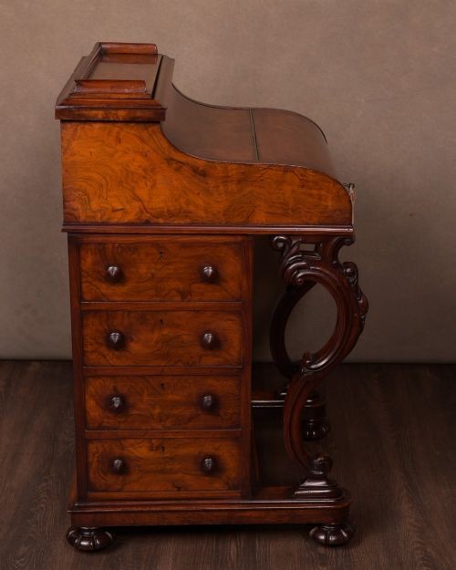 A Victorian burr walnut pop-up Davenport desk featuring carved scroll front supports, side drawers with wooden knobs, and a hinged sloping top. View XI