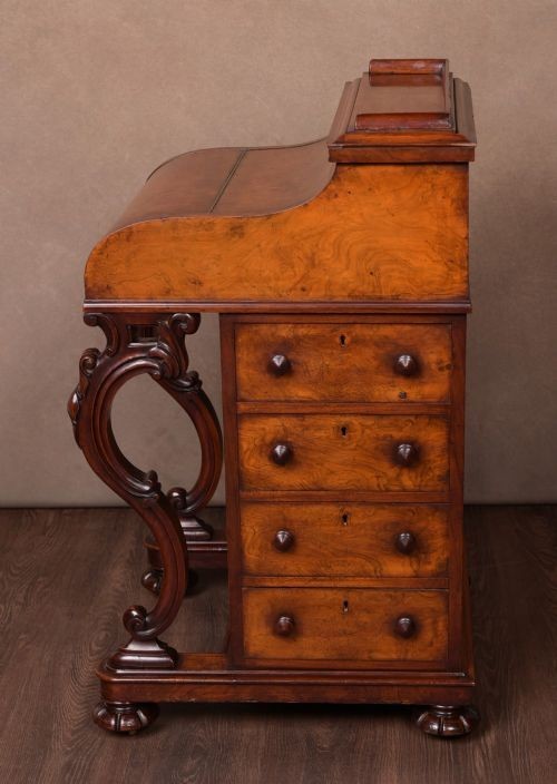 A Victorian burr walnut pop-up Davenport desk featuring carved scroll front supports, side drawers with wooden knobs, and a hinged sloping top. View XIV