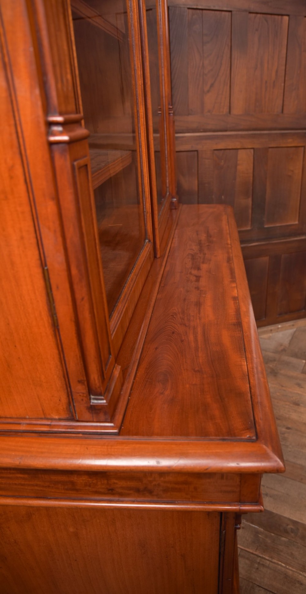 A Victorian mahogany two-part bookcase featuring a moulded cornice, two upper glazed doors with adjustable shelves, and a lower base with two arched panelled cupboard doors. View XIII