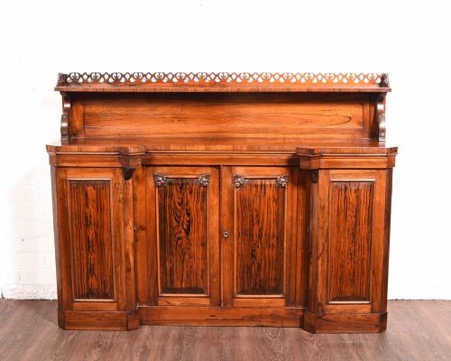 A 19th-century rosewood breakfront side cabinet featuring rich grain panels, carved accents, and a pierced top gallery rail.