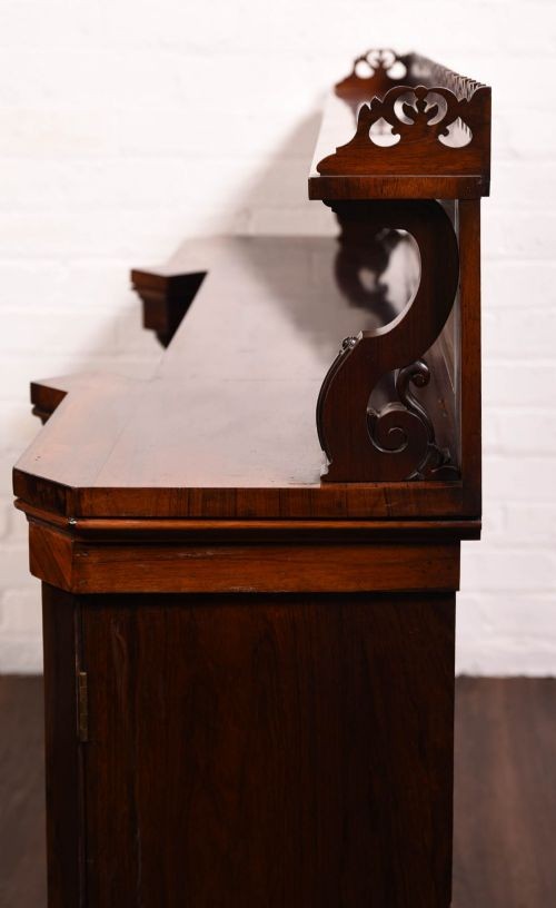 A 19th-century rosewood breakfront side cabinet featuring rich grain panels, carved accents, and a pierced top gallery rail. View XV