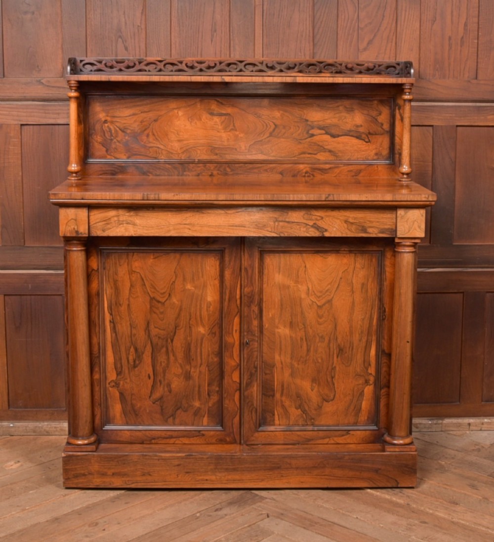 A Victorian rosewood chiffonier side cabinet featuring a raised back shelf with open fretwork gallery, turned columns, and a double-door cupboard base.